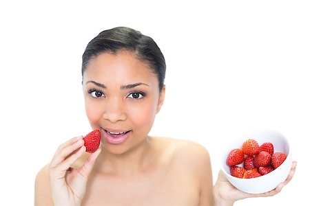 Relaxed young dark haired model eating strawberries on white background Photographie de stock - Aubaine LD & Abonnement, Code: 400-07127114