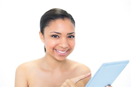 Smiling young dark haired model using a tablet pc on white background Foto de stock - Super Valor sin royalties y Suscripción, Código: 400-07127112