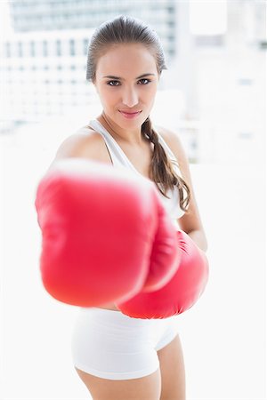 Sporty brunette boxing with red gloves in bright room Stock Photo - Budget Royalty-Free & Subscription, Code: 400-07128077