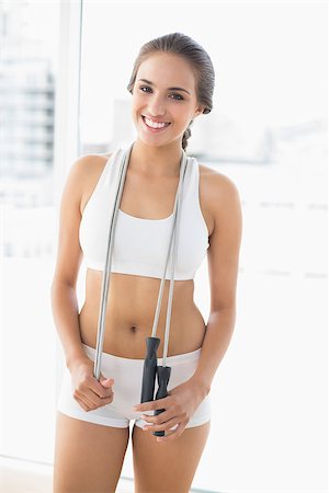 people exercising images skipping - Smiling sporty brunette wearing a skipping rope around the neck in bright room Stock Photo - Budget Royalty-Free & Subscription, Code: 400-07128131