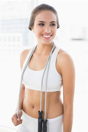 people exercising images skipping - Happy sporty brunette wearing a skipping rope around the neck in bright room Stock Photo - Budget Royalty-Free & Subscription, Code: 400-07128133