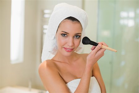 Cute natural brown haired woman applying powder on her face in a bright bathroom Stock Photo - Budget Royalty-Free & Subscription, Code: 400-07128774