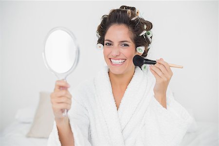 Cheerful natural brunette using brush and mirror in bedroom Photographie de stock - Aubaine LD & Abonnement, Code: 400-07128828