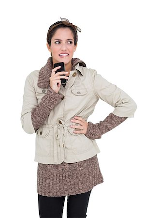 simsearch:649-02199405,k - Pensive cute brunette in winter fashion holding smartphone on white background Stockbilder - Microstock & Abonnement, Bildnummer: 400-07128972