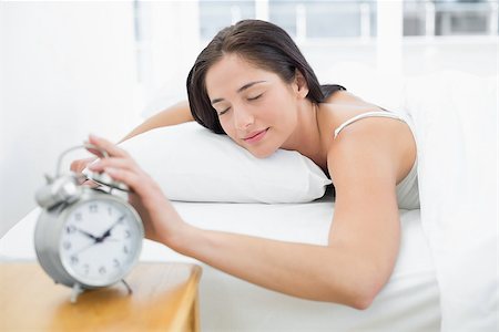 simsearch:614-02613098,k - Young woman in bed extending hand to alarm clock at home Stockbilder - Microstock & Abonnement, Bildnummer: 400-07134032