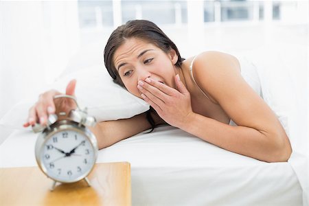 simsearch:614-02613098,k - Young woman yawning while extending hand to alarm clock in bed Stockbilder - Microstock & Abonnement, Bildnummer: 400-07134041
