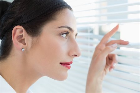 Close up side view of a young business woman peeking through blinds at office Stock Photo - Budget Royalty-Free & Subscription, Code: 400-07134326