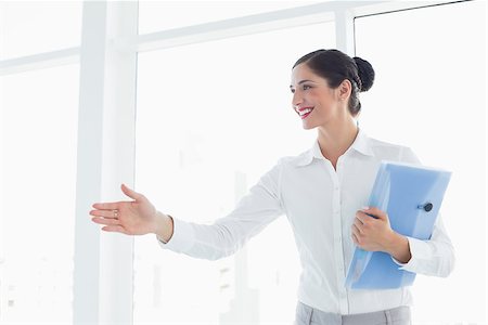 person entering office - Smiling young business woman with folder entering office cabin Stock Photo - Budget Royalty-Free & Subscription, Code: 400-07134321