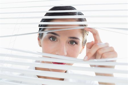 Close up portrait of a young business woman peeking through blinds Stock Photo - Budget Royalty-Free & Subscription, Code: 400-07134335