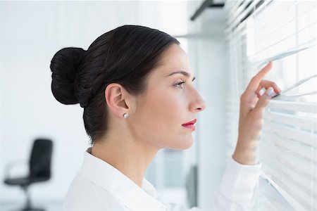 Close up side view of a young business woman peeking through blinds at office Stock Photo - Budget Royalty-Free & Subscription, Code: 400-07134330