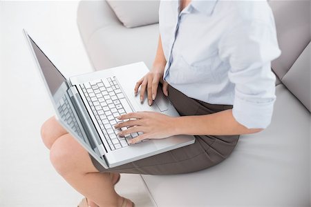 High angle view of a well dressed young woman using laptop on sofa at home Stock Photo - Budget Royalty-Free & Subscription, Code: 400-07135166