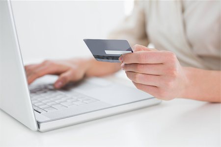 Close up mid section of a woman doing online shopping through laptop and credit card Stock Photo - Budget Royalty-Free & Subscription, Code: 400-07135451