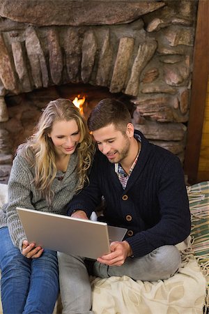 fireplace computer - Happy lovely young couple using laptop in front of lit fireplace Stock Photo - Budget Royalty-Free & Subscription, Code: 400-07135908