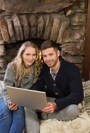 fireplace computer - Portrait of a lovely young couple using laptop in front of lit fireplace Stock Photo - Budget Royalty-Free & Subscription, Code: 400-07135909