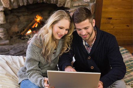 fireplace computer - Smiling lovely young couple using laptop in front of lit fireplace Stock Photo - Budget Royalty-Free & Subscription, Code: 400-07135910