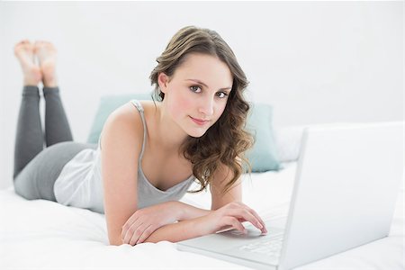 Portrait of a casual young brunette using laptop in bed at home Stock Photo - Budget Royalty-Free & Subscription, Code: 400-07136425