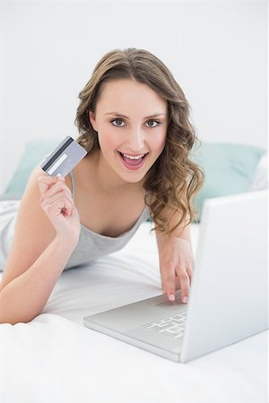 simsearch:649-07520743,k - Casual young woman doing online shopping through laptop and credit card in bed Photographie de stock - Aubaine LD & Abonnement, Code: 400-07136437