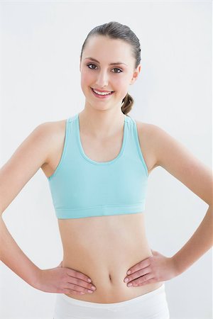 simsearch:400-07136501,k - Portrait of a smiling toned young woman with hands on hips in fitness studio Photographie de stock - Aubaine LD & Abonnement, Code: 400-07136491