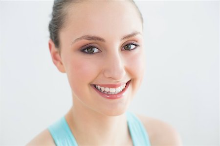 simsearch:400-07136501,k - Close up portrait of a smiling sporty young woman against wall in fitness studio Photographie de stock - Aubaine LD & Abonnement, Code: 400-07136549