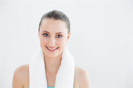 simsearch:400-07136501,k - Portrait of a fit young woman with towel around neck against wall at fitness studio Photographie de stock - Aubaine LD & Abonnement, Code: 400-07136550