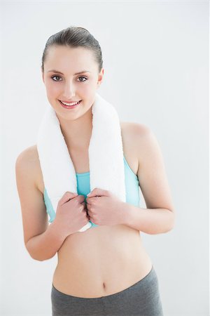 simsearch:400-07136501,k - Portrait of a fit young woman with towel around neck against wall at fitness studio Photographie de stock - Aubaine LD & Abonnement, Code: 400-07136552