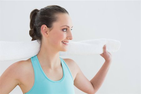 simsearch:400-07136501,k - Fit young woman with towel around neck against wall at fitness studio Photographie de stock - Aubaine LD & Abonnement, Code: 400-07136574