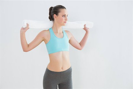 simsearch:400-07136501,k - Fit young woman with towel around neck against wall at fitness studio Photographie de stock - Aubaine LD & Abonnement, Code: 400-07136572