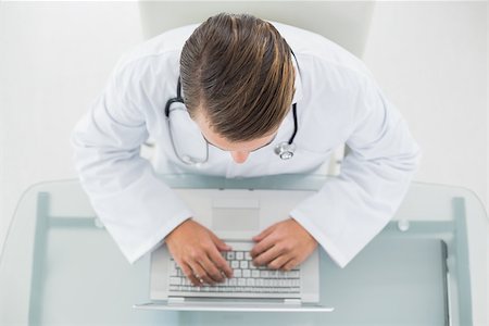 simsearch:695-05771285,k - Overhead view of a male doctor using laptop at medical office Foto de stock - Royalty-Free Super Valor e Assinatura, Número: 400-07136986