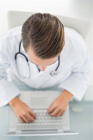 simsearch:695-05771285,k - Overhead view of a male doctor using laptop at medical office Foto de stock - Royalty-Free Super Valor e Assinatura, Número: 400-07136989