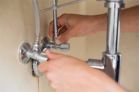 plumbing repairs - Extreme Close up of a plumber's hands and washbasin drain at bathroom Stock Photo - Budget Royalty-Free & Subscription, Code: 400-07137017