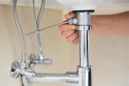 plumbing repairs - Extreme Close up of a plumber's hand and washbasin drain at bathroom Stock Photo - Budget Royalty-Free & Subscription, Code: 400-07137018