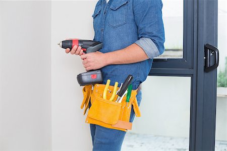 Mid section of a handyman with drill and toolbelt by the wall Stock Photo - Budget Royalty-Free & Subscription, Code: 400-07137037
