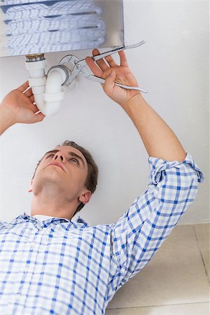 Close up of a young plumber repairing washbasin drain in bathroom Stock Photo - Budget Royalty-Free & Subscription, Code: 400-07137106