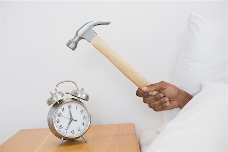 simsearch:614-02613098,k - Close up of an Afro man's hand smashing alarm clock with hammer in bed at home Stockbilder - Microstock & Abonnement, Bildnummer: 400-07137458