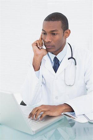simsearch:695-05771285,k - Concentrated male doctor using laptop at medical office Foto de stock - Royalty-Free Super Valor e Assinatura, Número: 400-07137499