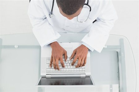 simsearch:695-05771285,k - Overhead view of a male doctor using laptop at medical office Foto de stock - Royalty-Free Super Valor e Assinatura, Número: 400-07137536