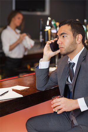 simsearch:400-07137867,k - Serious businessman having a phone call in a classy bar Fotografie stock - Microstock e Abbonamento, Codice: 400-07137814