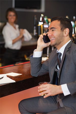 simsearch:400-07137867,k - Smiling businessman having a phone call in a classy bar Fotografie stock - Microstock e Abbonamento, Codice: 400-07137815