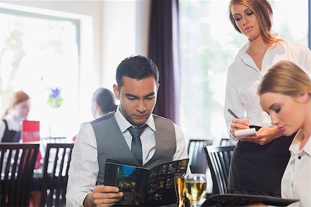 simsearch:400-07137867,k - Handsome businessman reading the menu in a fancy restaurant Fotografie stock - Microstock e Abbonamento, Codice: 400-07137860