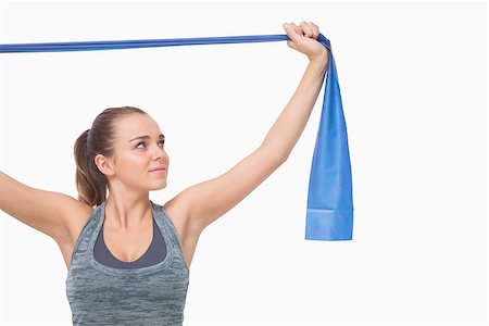 Ponytailed young woman training using a resistance band n white background Stock Photo - Budget Royalty-Free & Subscription, Code: 400-07138144