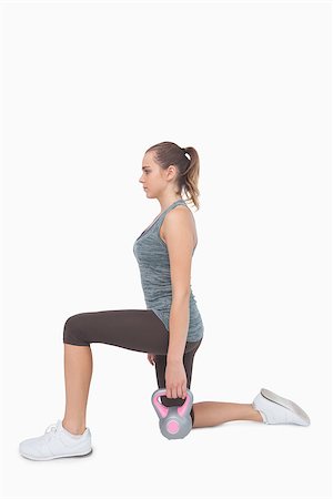 simsearch:400-07138263,k - Blonde woman training with kettle bell while lunging on white screen Stock Photo - Budget Royalty-Free & Subscription, Code: 400-07138194