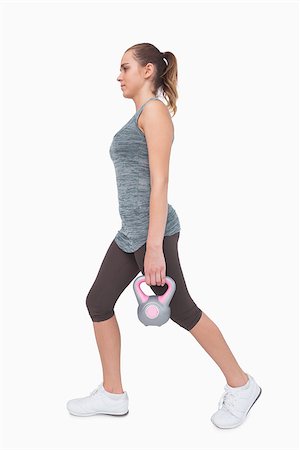 simsearch:400-07138263,k - Sporty woman training her body walking with a kettle bell on white screen Stock Photo - Budget Royalty-Free & Subscription, Code: 400-07138196