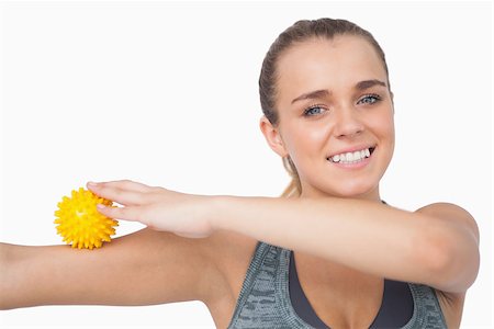 simsearch:400-07138263,k - Cheerful young woman touching arm with massage ball on white screen Stock Photo - Budget Royalty-Free & Subscription, Code: 400-07138198