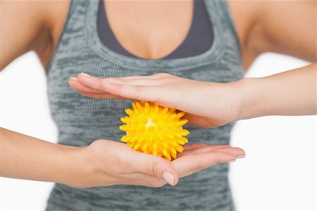 simsearch:400-07138263,k - Mid section of young woman holding yellow massage ball on white screen Stock Photo - Budget Royalty-Free & Subscription, Code: 400-07138205