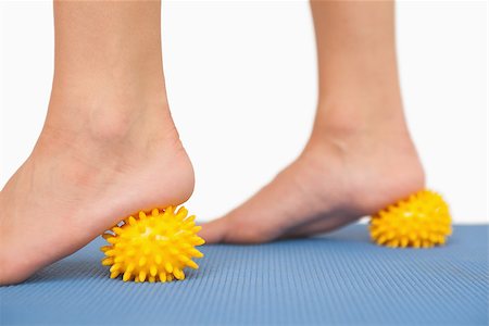 Female feet touching yellow massage ball standing on blue gound Stock Photo - Budget Royalty-Free & Subscription, Code: 400-07138209