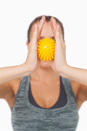 simsearch:400-07138263,k - Young woman holding yellow massage ball between hands in front of her face Stock Photo - Budget Royalty-Free & Subscription, Code: 400-07138202