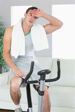 Exhausted handsome man training on exercise bike in bright living room Stock Photo - Budget Royalty-Free & Subscription, Code: 400-07138393