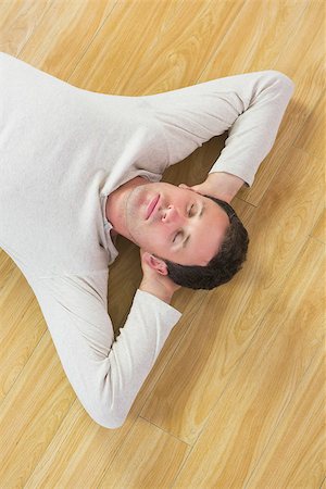 simsearch:400-07931092,k - Casual peaceful man lying on floor with closed eyes in bright room Foto de stock - Super Valor sin royalties y Suscripción, Código: 400-07139134