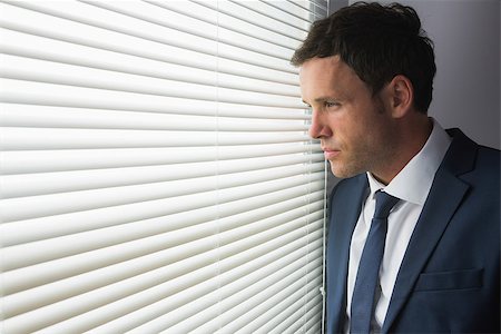 simsearch:400-07139155,k - Serious handsome businessman looking out of window in dark room Stock Photo - Budget Royalty-Free & Subscription, Code: 400-07139142