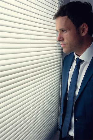 simsearch:400-07139155,k - Stern handsome businessman looking out of window in dark room Stock Photo - Budget Royalty-Free & Subscription, Code: 400-07139143